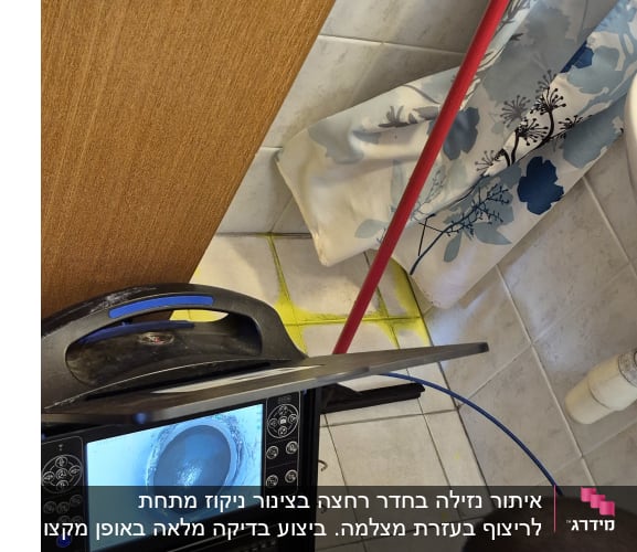 אדם משתמש במכשיר לאיתור נזילות בחדר אמבטיה